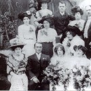 Photo:Wedding of Rose Ray and Samuel Wood. In front row, next to Samuel, is Rose's cousin Lulu, and next to her is her husband George Kelsey. Top row, on right is Rose's brother Jim and his wife Minnie (from previous wedding photo).